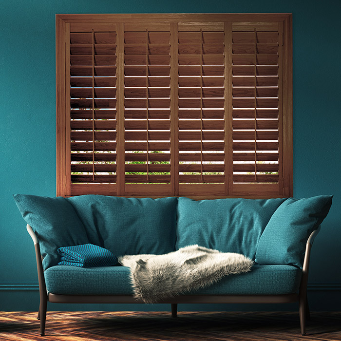 Dark brown stain shutters in a green living room