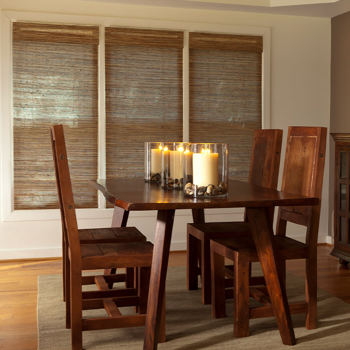 Brown woven shades in a dining room with candlelight.