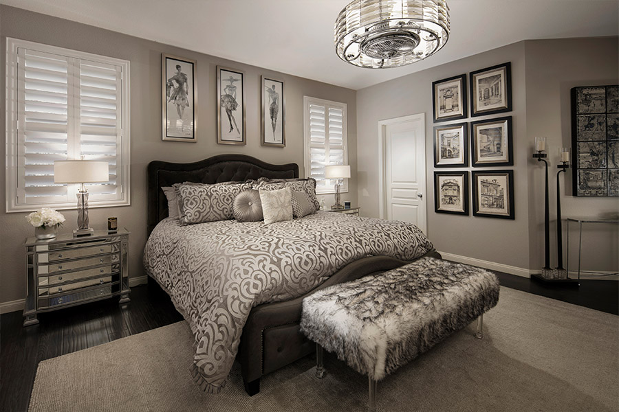 large, luxurious bed in the middle of two smaller windows with white plantation shutters