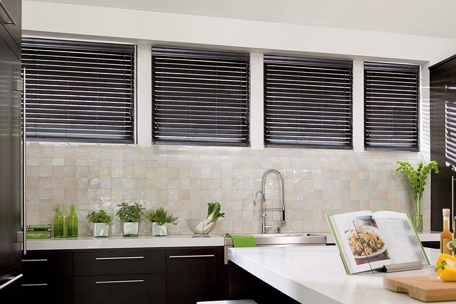 Choose custom Polywood faux wood blinds for your kitchen in Jacksonville. Special shaped faux wood blinds in several windows above a sink.