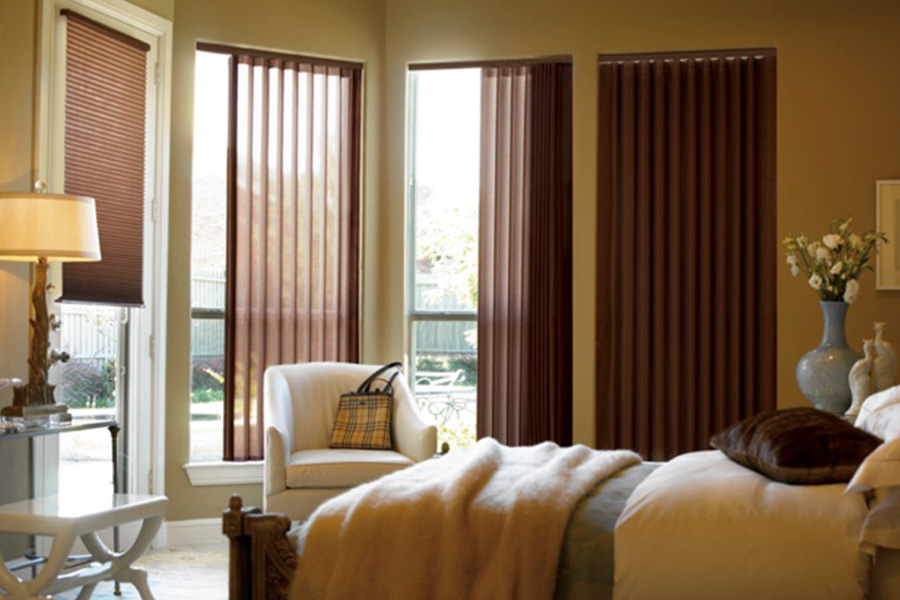 Choose durable and high-quality fabric or vinyl vertical blinds in Jacksonville. Maroon fabric vertical blinds inside a bedroom