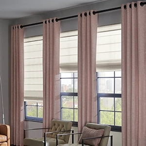 Pink flowing draperies over four medium sized windows within a large living room