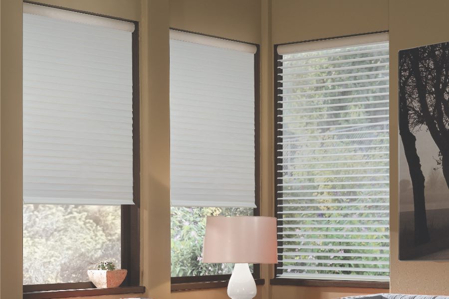 Opaque motorized window shades in Jacksonville keep hot UV rays out of your home. Gray motorized sheer shades on corner windows next to gray furniture