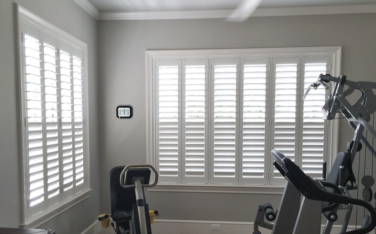 Weatherstripping window coverings are especially important in spaces with windows on multiple walls. Jacksonville exercise room with shuttered windows.