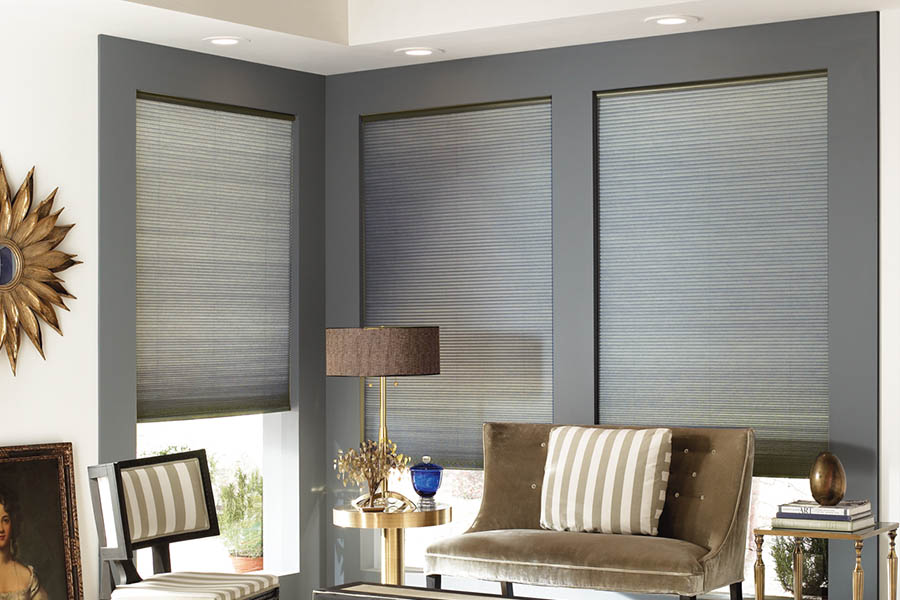 Add style and comfort to your home with cellular shades in Jacksonville. Gray cellular shades in a corner of a stylish living room.