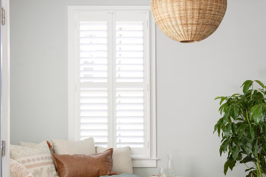 Polywood shutters are repairable against your dog's excitable energy. Photo Credit: Wendy Maruo Design Margaret. White polywood shutters in a small living room.