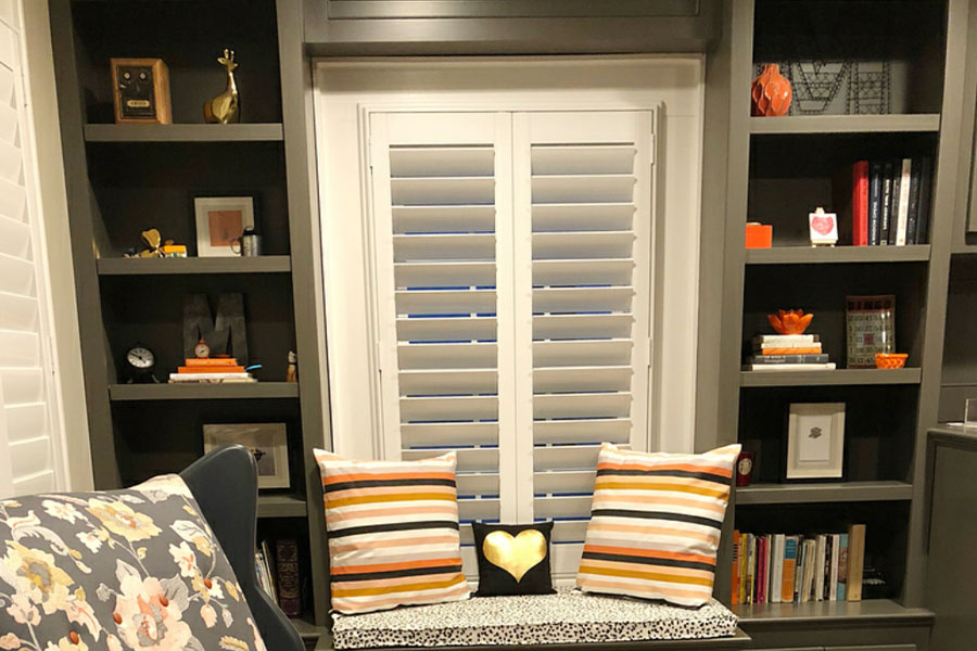 Polywood shutters block outside noise and distractions when you're reading in your home library. photo credit: MeaghanBMurphy White polywood shutters in a small library room at home.