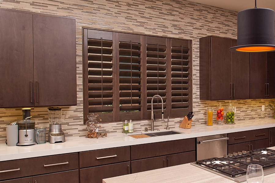 Save your lovely wood shutter finish with gentle cleaning. Brown wood shutters on a kitchen sink window