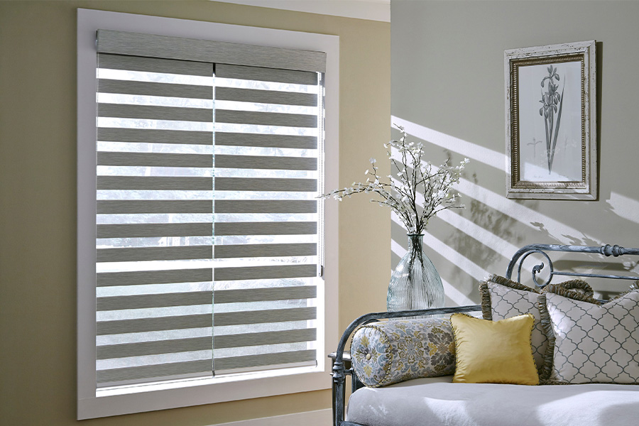 Find Functional and stylish window blinds for Jacksonville homes at Sunburst. Gray blinds on a large window next to a couch.