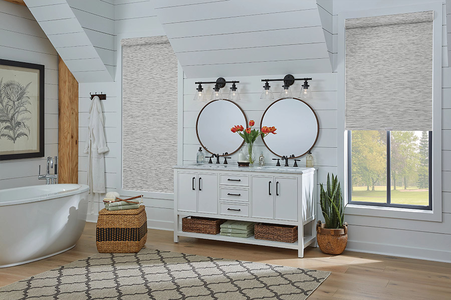 Slim-profile roller shades easily fit shallow windows in your Jacksonville home. Gray patterned roller shades on bathroom windows